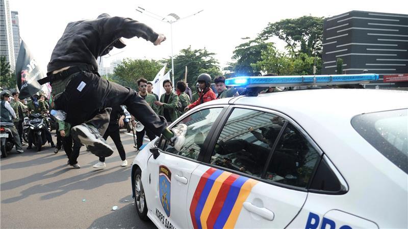 Bilder des Tages Massenproteste gegen die Regierung in Indonesien: ein Demonstrant attackiert ein Polizeiauto.