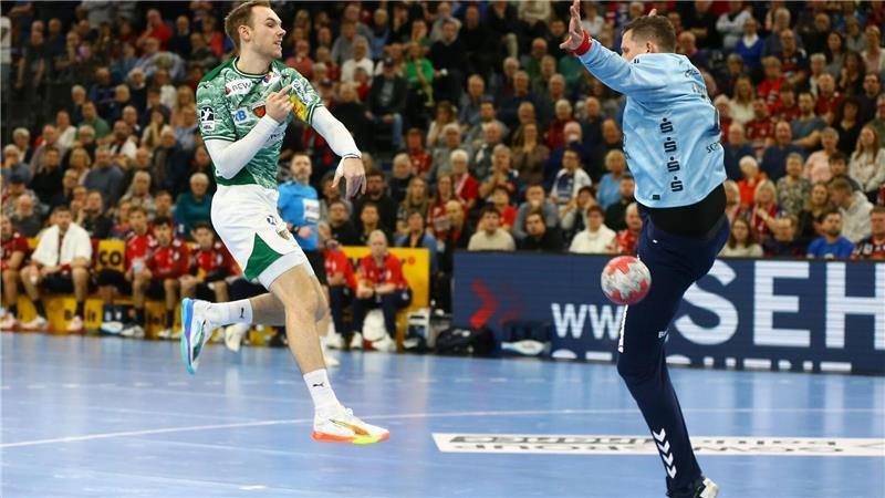 Mathias Gidsel (Füchse Berlin, l) wirft gegen den Flensburger Torwart Kevin Möller.