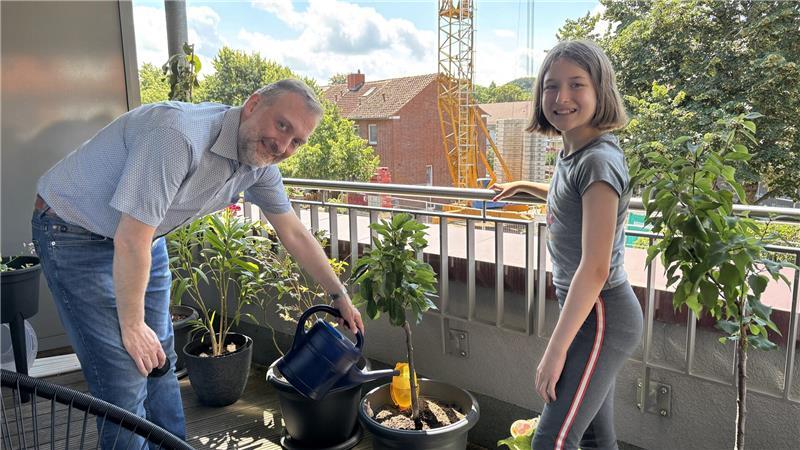 Matthias Bunzel und Tochter Vera freuen sich über ihren überdachten Balkon, auf dem viele Pflanzen wachsen. Von hier aus haben sie einen direkten Blick auf die Wohnstättenzentrale in der Teichstraße.