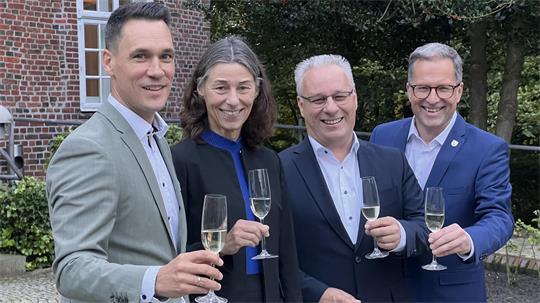 Matthias Reichert (v. li.), Dr. Dagmar Linse, Stephan Engel und Landrat Kai Seefried stoßen mit einem Glas Sekt an.