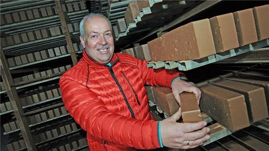 Matthias Rusch zeigt die aus Tonerde gepressten Klinker. Vier Tage müssen sie trocknen, bevor sie in den Ringofen zum Brennen kommen.