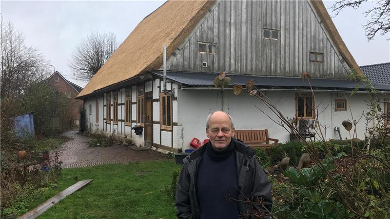 Matthias Schlüter vor seinem Reetdachhaus mit frisch gedecktem Dach.
