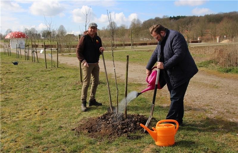 Matthias Schuh (links) und Stefan Zimmermann pflanzen den „Kantapfel“ in den Entdeckergarten . Foto: FLMK