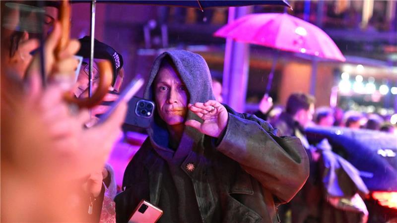 Matthias Schweighöfer auf dem roten Teppich - mit Fans und Regenschirmen.