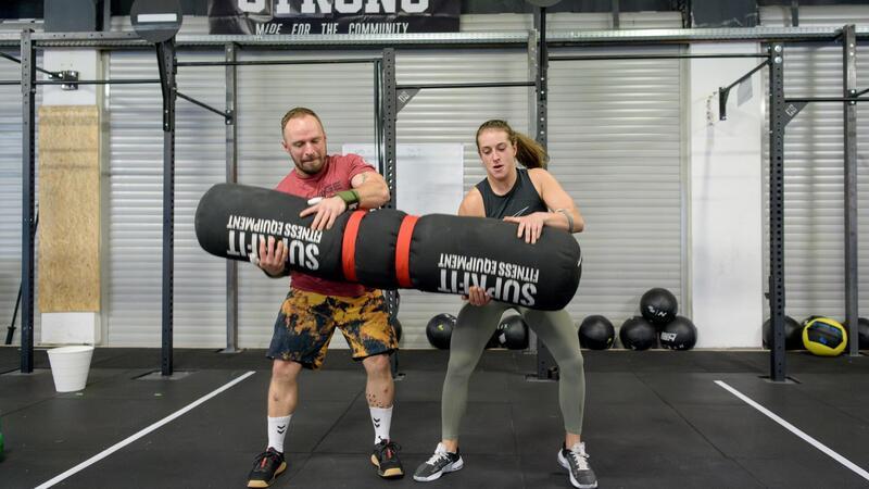 Fitness-Bundesliga: Wo die Quälerei Teamarbeit ist Maurice Monte und Jana Joy Vorrenhagen heben gemeinsam den „Wurm“ hoch, einen 50 Kilogramm schweren Sack. Solche Trainingsgeräte sind typisch für Crossfit.