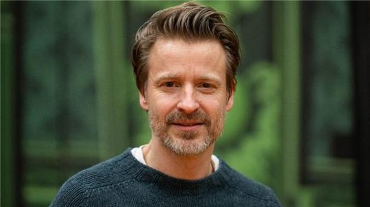 Max von Pufendorf, Schauspieler, steht vor einer Theaterkulisse vom Stück „Cluedo“ auf der Probebühne der Komödie am Kurfürstendamm im Theater am Potsdamer Platz.