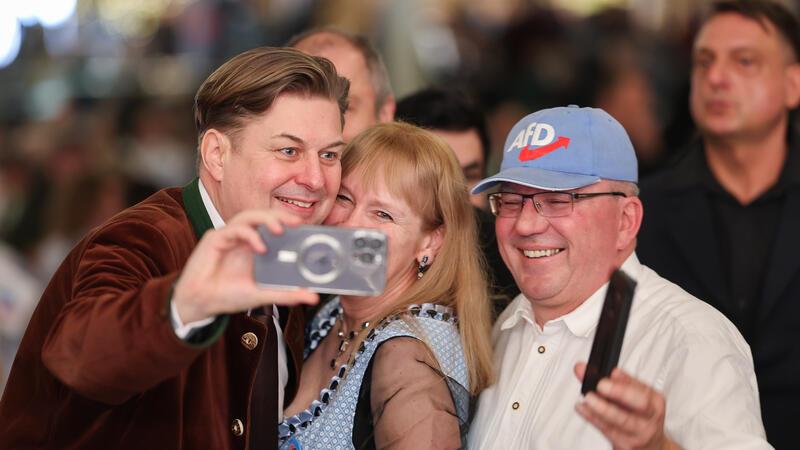 TikTok schränkt Reichweite von AfD-Politiker Krah ein - Videos gesperrt Maximilian Krah (links), Spitzenkandidat der AfD für die Europawahl, macht Fotos mit Teilnehmenden des politischen Aschermittwochs der AfD. Die Plattform Tiktok hat die Reichweite des Politikers nun eingeschränkt.
