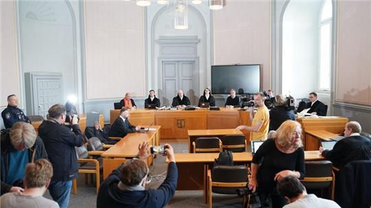 Medienvertreterinnen und Medienvertreter fotografieren und filmen den Angeklagten (5.v.l) im Sitzungssaal im Landgericht Kiel zu Beginn des Prozesses wegen schwerer Körperverletzung und Vergewaltigung.
