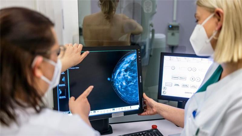 Medizinisches Personal untersucht mit einer Mammografie die Brust einer Frau auf Brustkrebs.