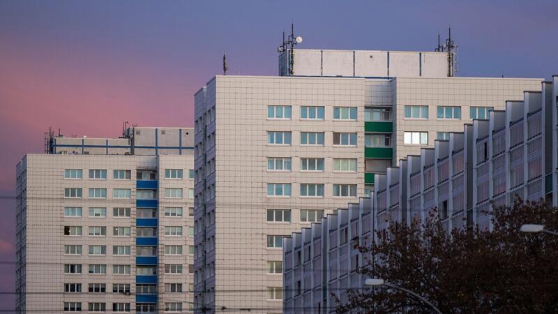 Mehrere Wohnungsblöcke sind vor der dem Abendhimmel zu sehen.