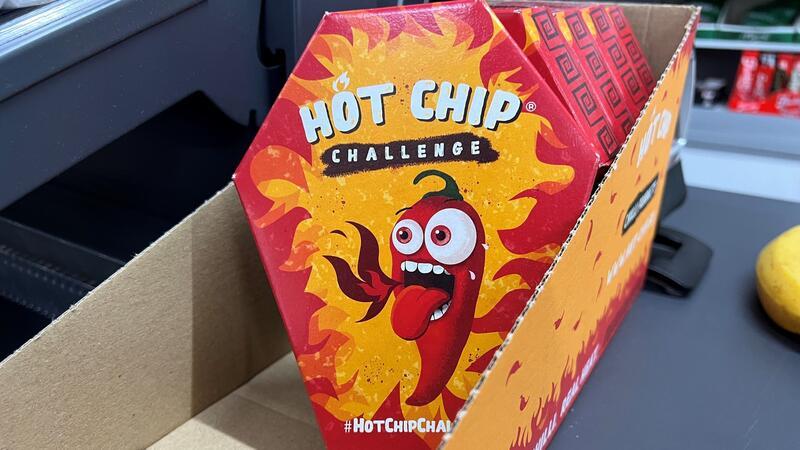 Mehrerer Packungen der „Hot Chip Challenge“ in einem Späti neben der Kasse.