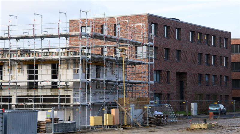 Mehrfamilienhäuser mit Wohnungen werden in einem Neubaugebiet gebaut (Symboldbild). Foto: Julian Stratenschulte/dpa