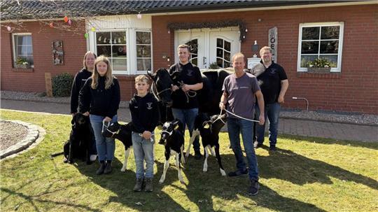 Meike und Jürgen Oellerich mit ihren drei Kindern Nika, Jaron und Finn sowie Tierzuchttechniker Volker Stemmermann präsentieren die Kuh Somalia mit ihren Kälbern Sina, Simba und Samba. Auch Hund Paula kam mit aufs Bild.