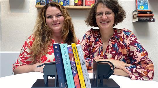 Melanie Hainke und Mariona Peglow vom Team des Buxtehuder Bullen mit den nominierten Buchtiteln im Vordergrund 