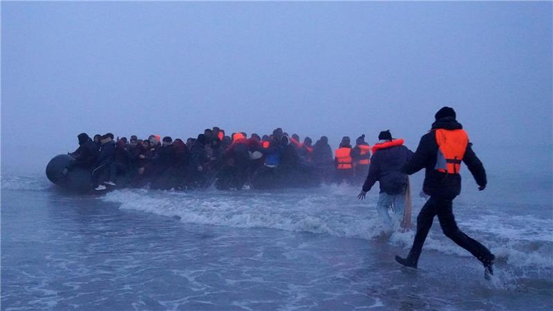 Menschen, bei denen es sich vermutlich um Migranten handelt, besteigen ein kleines Boot am Strand von Gravelines, Frankreich, um den Ärmelkanal zu überqueren.
