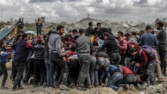 Menschen drängen sich um Pakete mit humanitärer Hilfe, die über dem nördlichen Gazastreifen abgeworfen wurden. Israel hat „sofortige Schritte“ zur Erhöhung humanitärer Hilfe für die Zivilbevölkerung beschlossen.