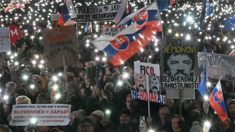 Menschen erinnern während einer Demonstration an den siebten Jahrestag des Mordes am Investigativjournalisten Kuciak und seiner Verlobten Martina Kusnirova und demonstrieren sie gegen die Ukraine- und Russland-Politik des linksnationalen Ministerpräsidenten Fico.