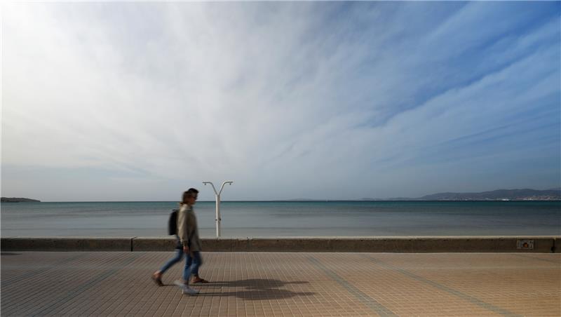 Menschen gehen an der Strandpromenade von Arenal auf Mallorca entlang. Die Vorbereitungen in der deutschen Urlauberhochburg laufen auf Hochtouren. Foto: Clara Margais/dpa