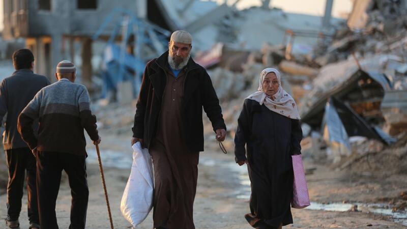USA: Tote nach Huthi-Angriff auf Frachtschiff Menschen gehen an zerstörten Gebäuden im Flüchtlingslager Al-Maghazi im Zentrum des Gazastreifens vorbei. Das Bangen um eine Feuerpause vor Ramadan geht weiter.