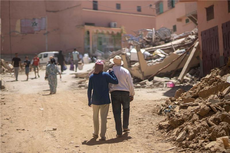 Schon fast 2900 Tote nach Erdbeben in Marokko: Hoffnung schwindet Menschen gehen durch die Trümmer des Erdbebens in der Stadt Amizmiz in der Nähe von Marrakesch.