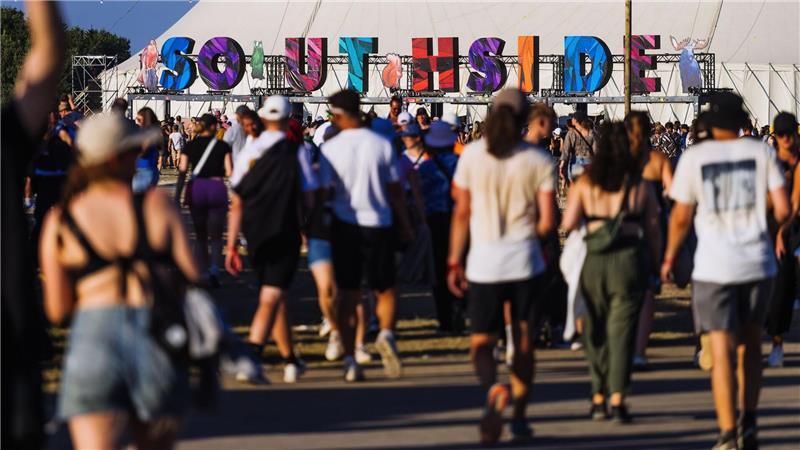 Menschen gehen über das Gelände des Southside Festivals.