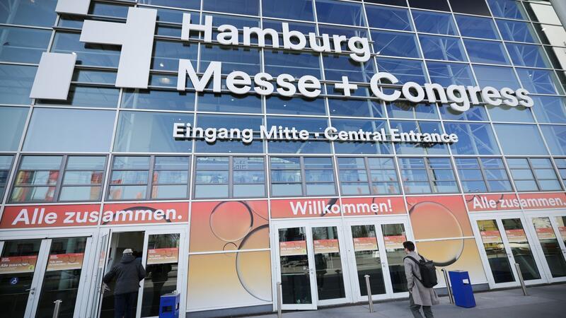 Menschen gehen zum Eingang der Gastronomie-Leitmesse „Internorga“ in den Messehallen.