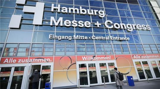 Menschen gehen zum Eingang der Gastronomie-Leitmesse „Internorga“ in den Messehallen.