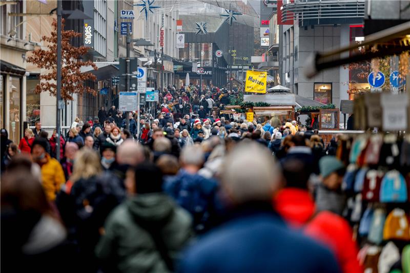 Menschen gehen zum Einkaufen durch die Kieler Innenstadt. Foto: Axel Heimken/dpa