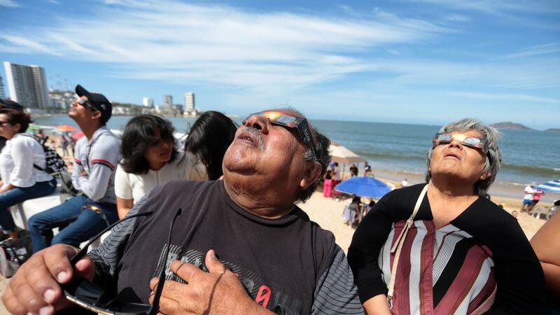 Millionen Menschen sehen totale Sonnenfinsternis Menschen haben sich im Hafen von Mazatlán in Mexiko versammelt, um die totale Sonnenfinsternis beobachten.