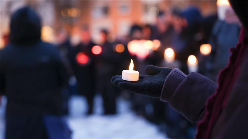 Menschen halten Lichter am Joseph-Carlebach-Platz.