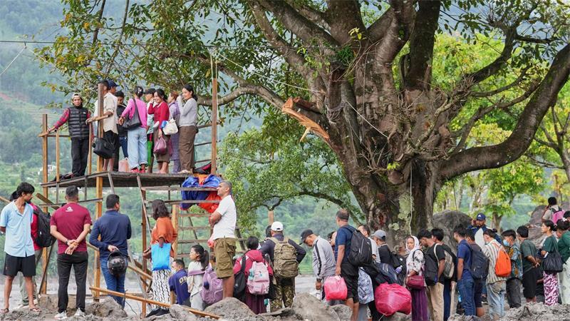 Menschen im Katastrophengebiet in Nepal warten darauf, in eine provisorische Seilbahn besteigen zu können. 