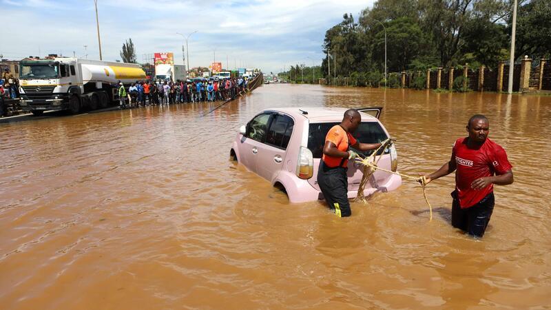 Bereits 257 Flutopfer in Kenia Menschen in Nairobi, die im Hochwasser ein Auto ziehen.
