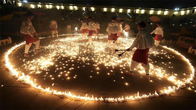 Menschen in traditioneller Tracht führen während der neuntägigen Feierlichkeiten des hinduistischen Festes Navratri in Ahmedabad in Indien den „Mashal Raas“ auf.