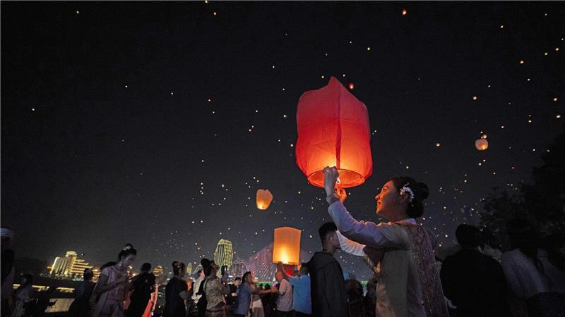 Menschen lassen Laternen steigen am Fluss Lancang in Yunnan