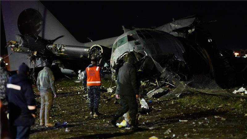 Menschen laufen an der Stelle vorbei, an der ein Flugzeug auf einer Autobahn in El Alto, Bolivien, abgestürzt ist.