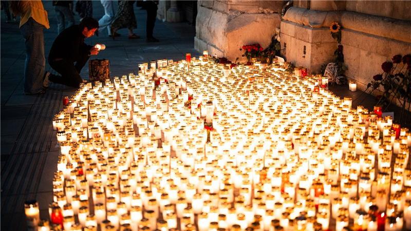 Bilder des Tages Menschen legen nach dem Amoklauf in einer Schule in Graz Kerzen vor dem Stephansdom nieder.