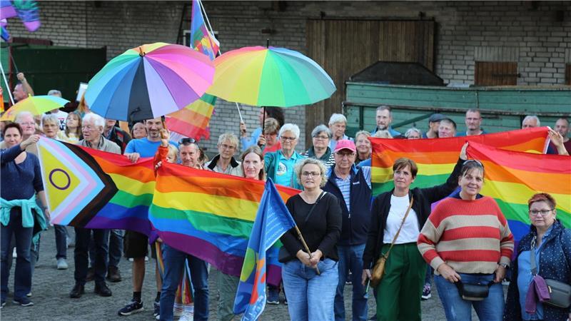 Menschen mit Regenbogenflaggen und -schirmen beteiligten sich am Freitagabend an einer Kundgebung.