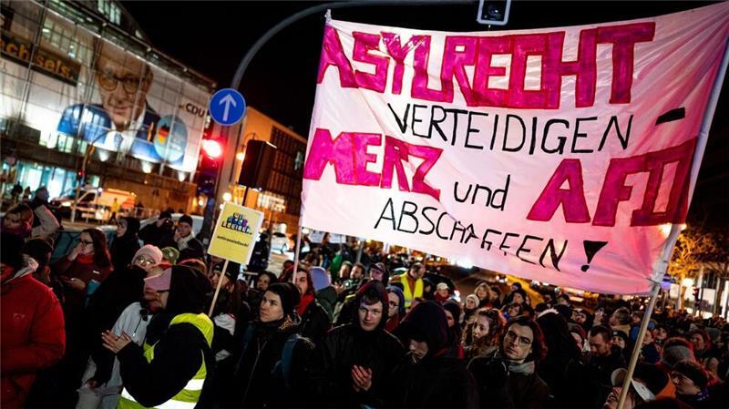 Menschen nehmen an der Kundgebung „Brandmauer statt Brandstiftung“ von Amnesty International, Seebrücke und anderen Organisationen mit einem Transparent mit der Aufschrift „Asylrecht verteidigen Merz und AfD abschaffen“ vor der CDU-Zentrale in Berlin teil.
