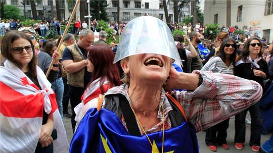 Menschen protestieren vor dem Parlamentsgebäude in Tiflis gegen das Gesetz über ausländische Einflussnahme.