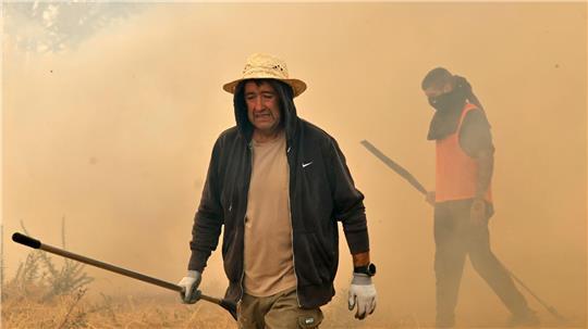 Menschen reagieren bei der Bekämpfung eines Waldbrandes in Veiga das Meas im Nordwesten Spaniens.