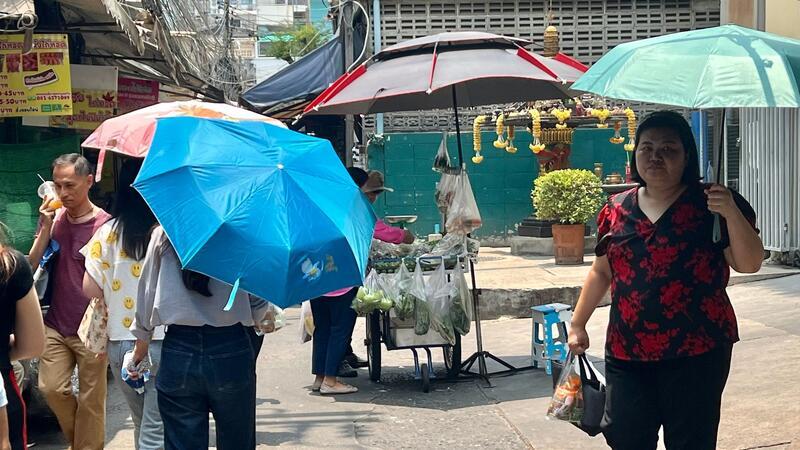 Rekord-Hitzewelle in Thailand führt zu mehr als 60 Toten Menschen schützen sich in Bangkok mit Schirmen vor der extremen Hitze und vor der Sonne.
