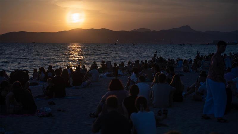 Menschen sitzen am Strand von Palma und warten auf die totale Sonnenfinsternis.