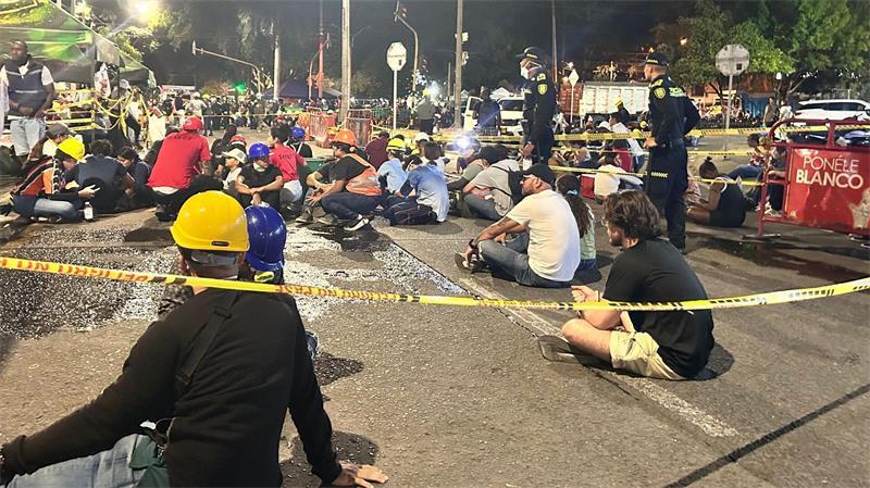 Plötzlich wird es still am Trümmerberg in Cali Menschen sitzen nach der Warnung wegen eines möglichen Nachbebens auf dem Boden.