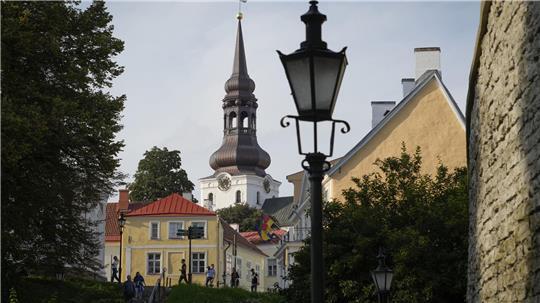 Menschen spazieren an einem sonnigen Tag in der Altstadt von Tallinn.
