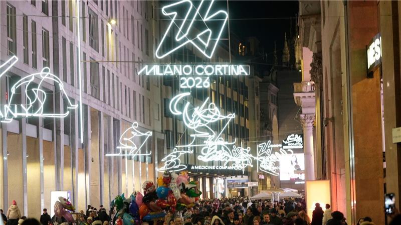 Menschen spazieren durch das Stadtzentrum Mailands, welches mit Beleuchtung für die bevorstehenden Olympischen Winterspiele in Italien 2026 geschmückt ist.