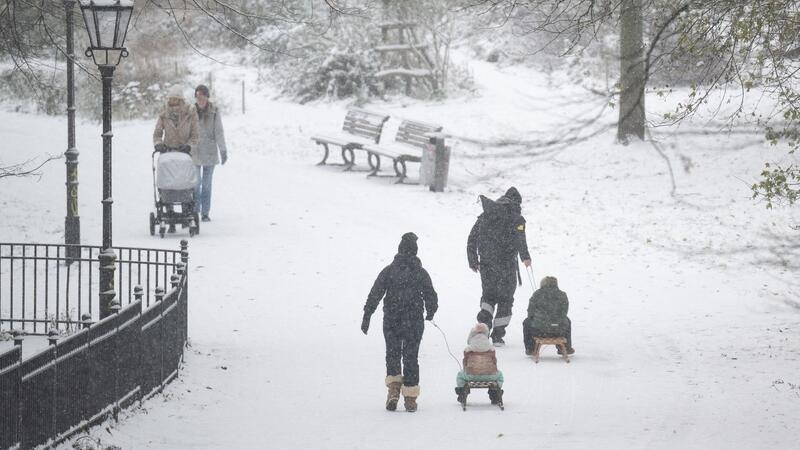 Winter geht weiter: Kälte, Schnee - und auch noch Streiks Menschen spazieren durch den verschneiten Volkspark Friedrichshain in Berlin.