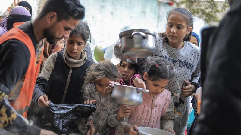 Not in Gaza verschärft sich - USA lehnen Waffenstillstand ab Menschen stehen in Rafah im Süden des Gazastreifens mit Töpfen, Schalen und Tüten bei einer Essensausgabe an.