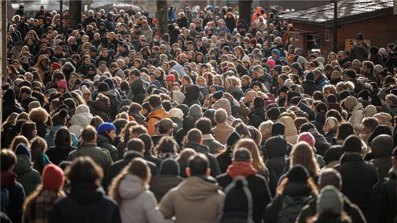 Menschen stehen zusammen während einer Schweigeminute bei der Trauerfeier für die Opfer des verheerenden Brandes in Crans-Montana in der Schweiz.