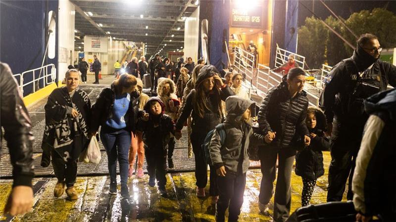 Menschen steigen im Hafen von Piräus in der Nähe von Athen von einer Fähre, mit der sie die griechische Insel Santorini verlassen haben.
