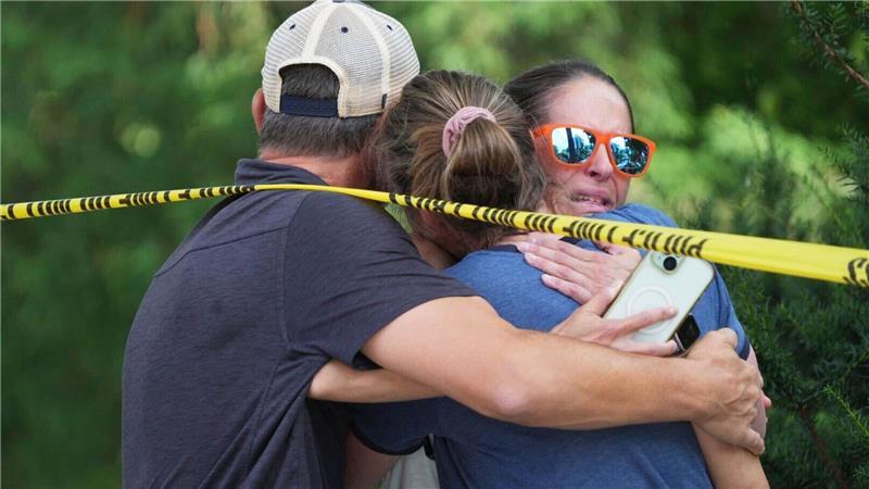 Menschen umarmen sich nach Schüssen an einer Schule, bei denen zwei Kinder gestorben sind.